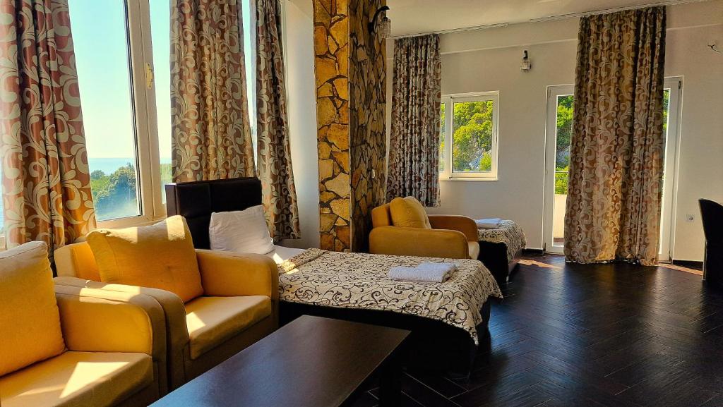 Quadruple Room at Azura Bay — sofas, beds and a sea-view balcony